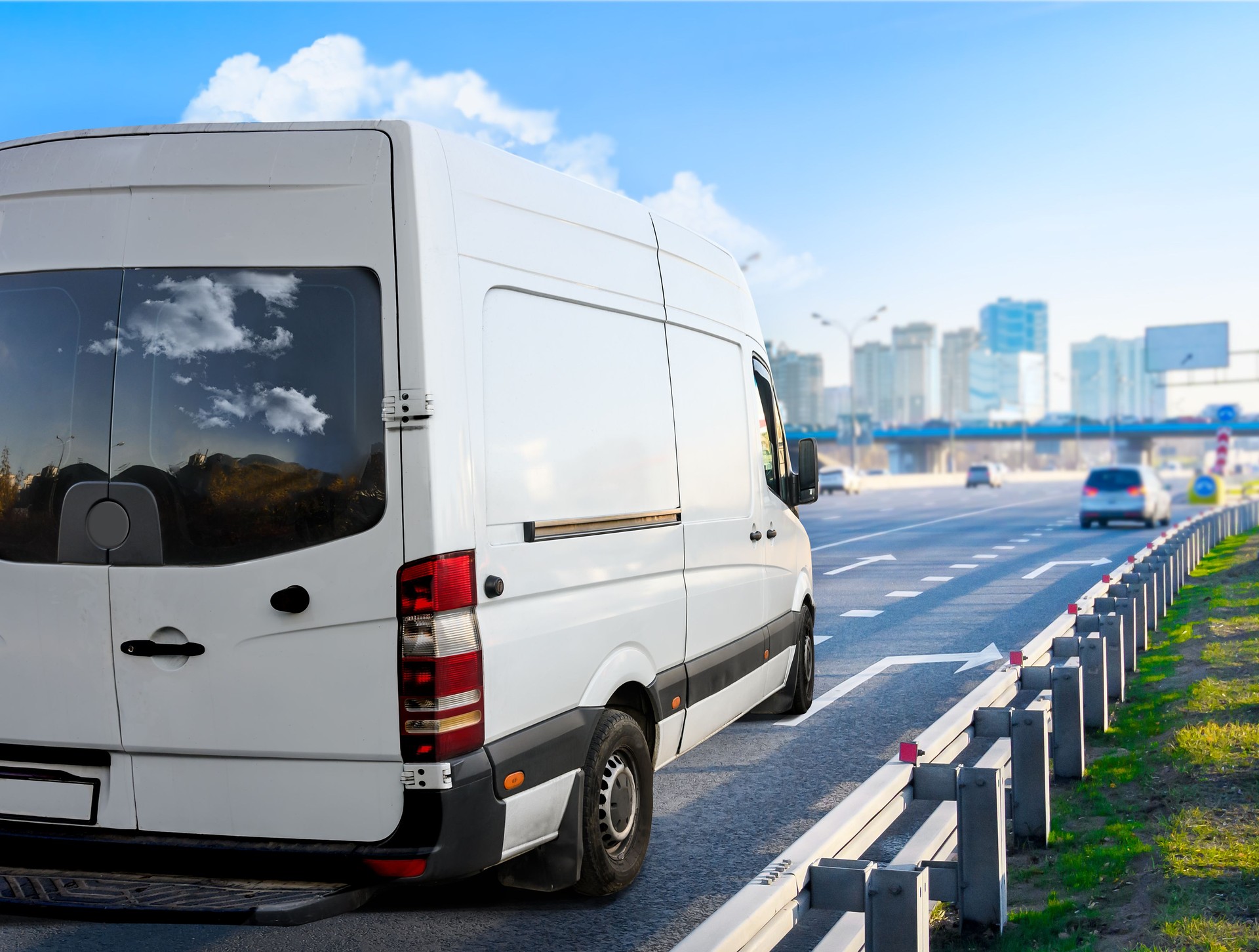 White van moving on the highway at cityscape background.